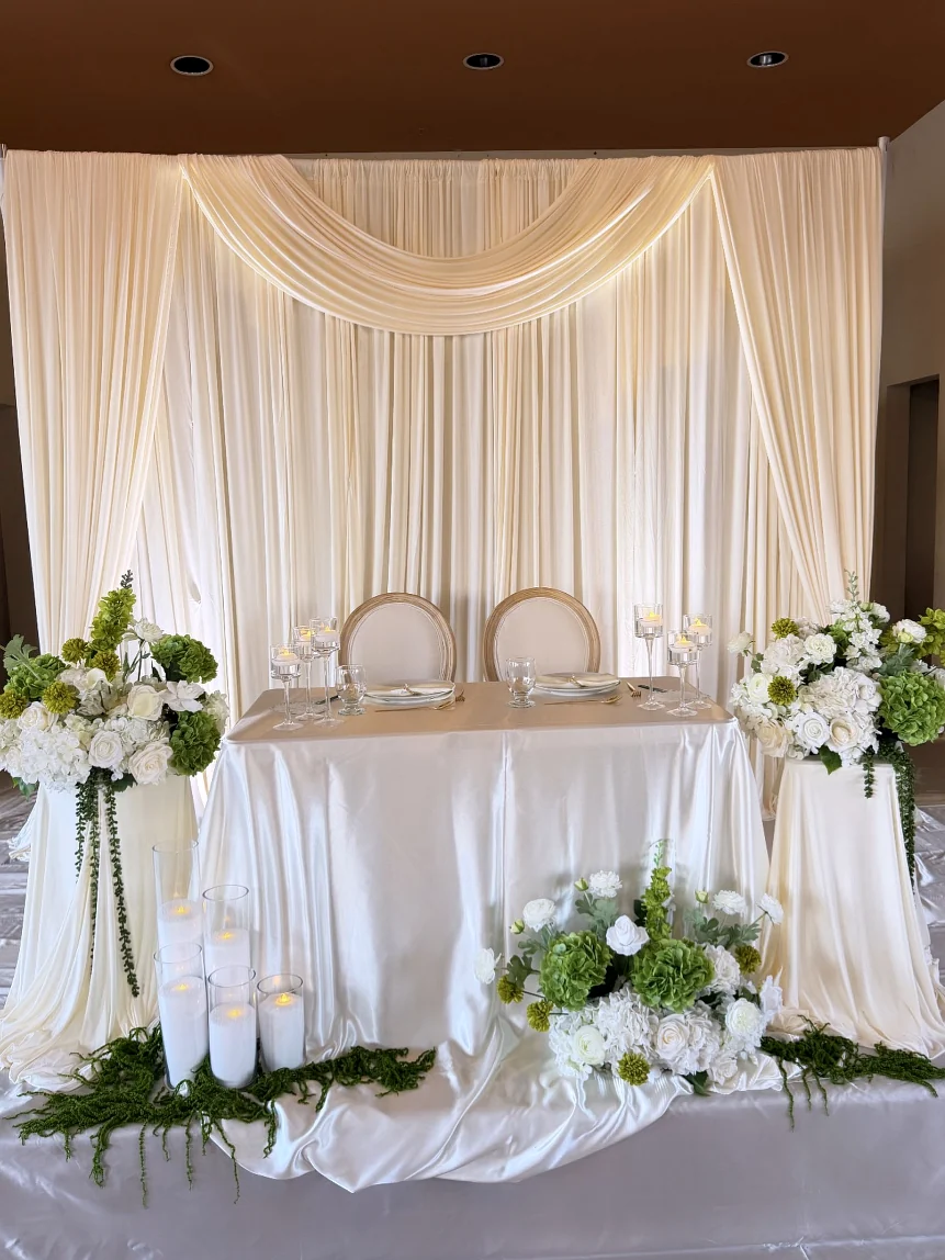 Sweetheart table with ivory draping, white and green hydrangeas and candles