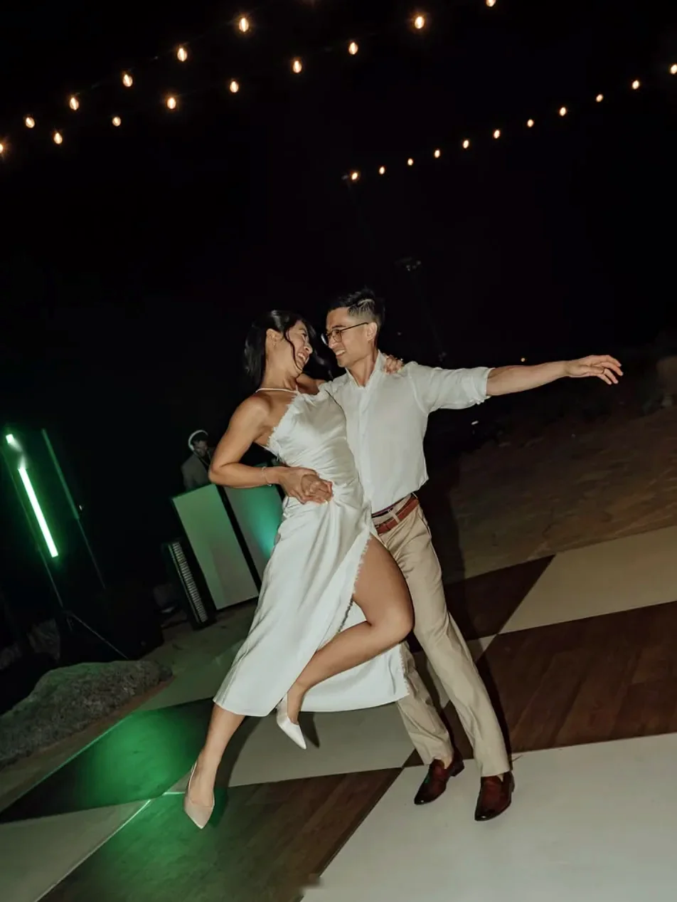 Couple dancing under string lights at night